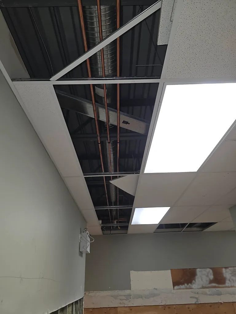 Overhead copper hot, cold and recirculation mains above a commercial ceiling grid, installed by PeakFlow Plumbing Calgary