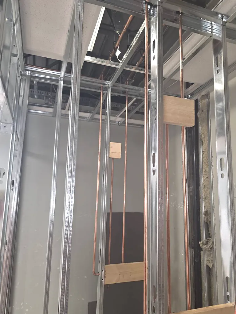 Copper hot and cold shower risers blocked into steel stud framing by PeakFlow Plumbing Calgary