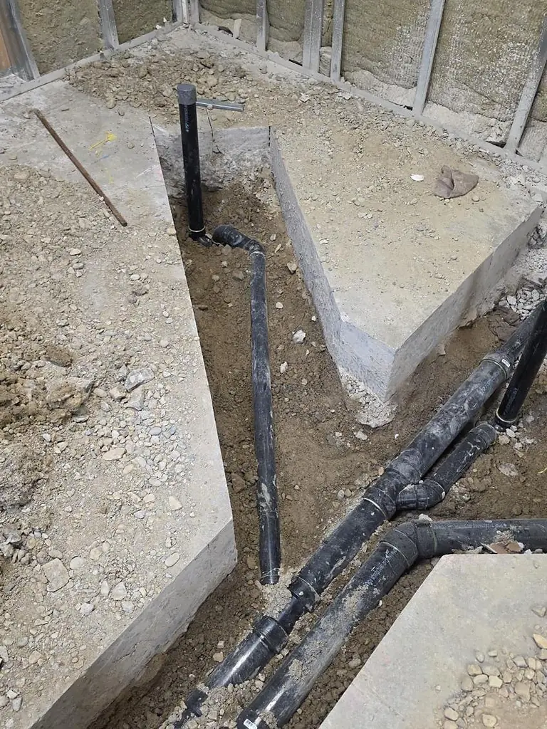 Underground drainage branch connections and stack riser installed by PeakFlow Plumbing Calgary