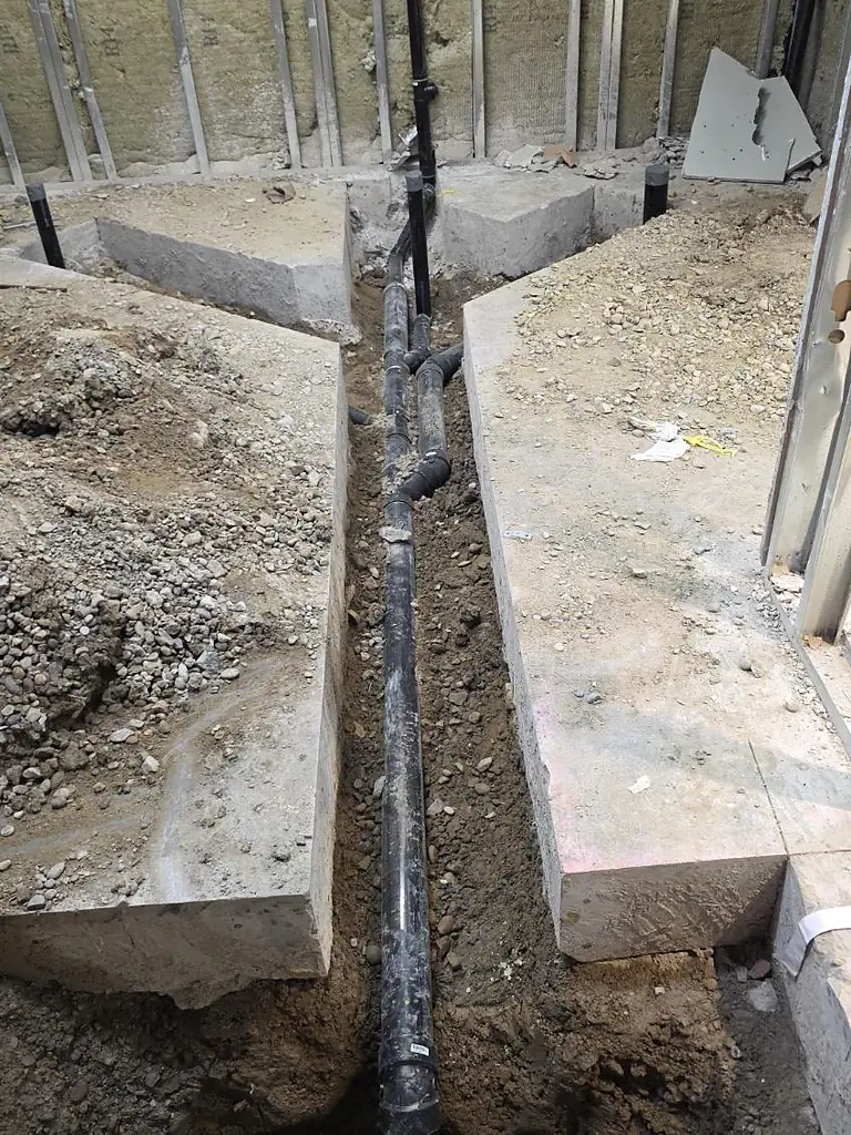 Underground drainage main run trenched between foundation footings by PeakFlow Plumbing Calgary